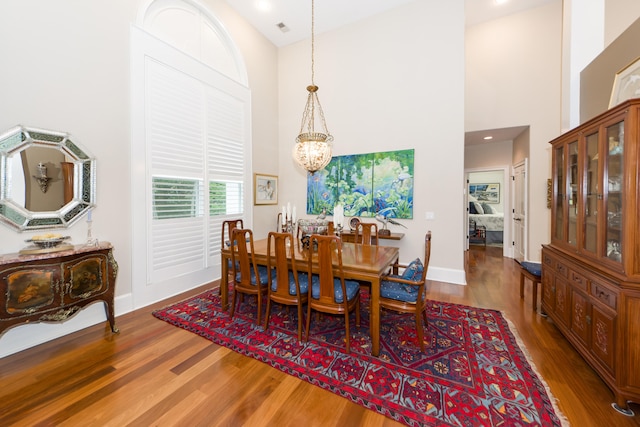 dining room with high vaulted ceiling, dark hardwood / wood-style flooring, and a notable chandelier