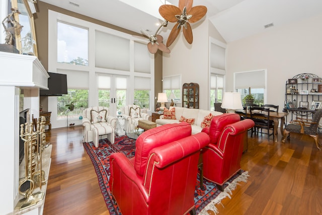 living room featuring a wealth of natural light, ceiling fan, high vaulted ceiling, and dark wood-type flooring