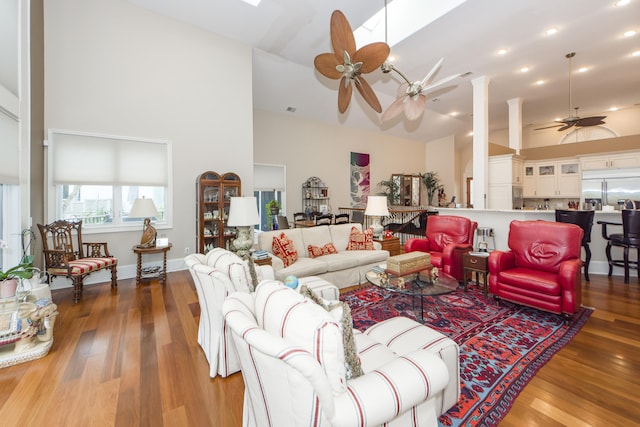 living room with high vaulted ceiling, hardwood / wood-style floors, and ceiling fan