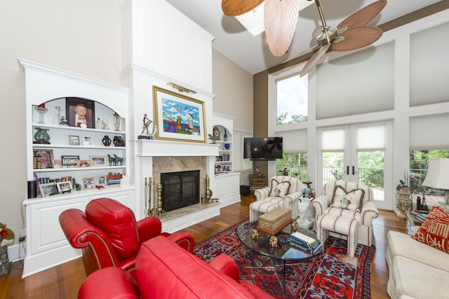 living room with dark hardwood / wood-style flooring, ceiling fan, and a high ceiling