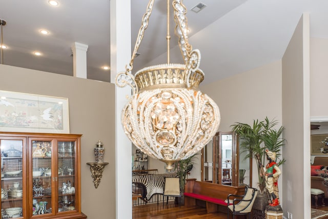 room details with hardwood / wood-style floors and an inviting chandelier