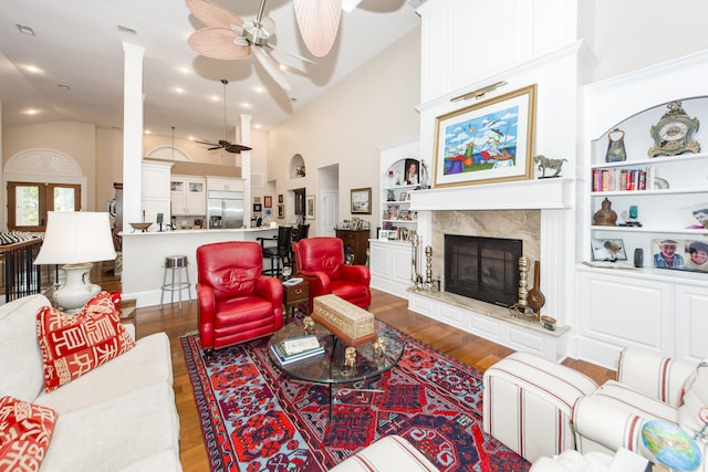 living room with high vaulted ceiling, ceiling fan, hardwood / wood-style flooring, and a fireplace