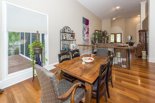 dining room with hardwood / wood-style flooring and vaulted ceiling