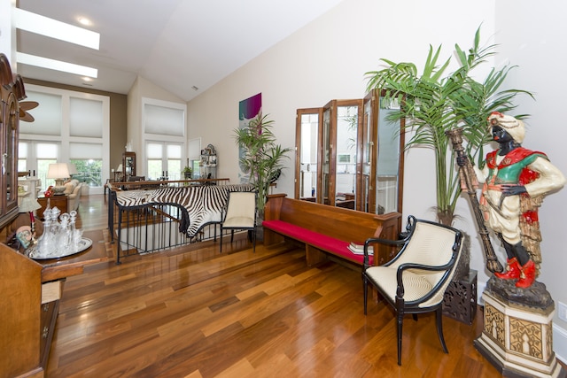 sitting room with hardwood / wood-style floors and vaulted ceiling