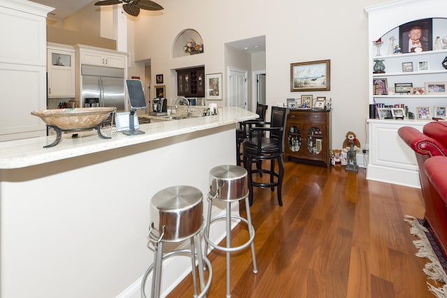 kitchen featuring built in refrigerator, dark hardwood / wood-style floors, ceiling fan, and white cabinetry