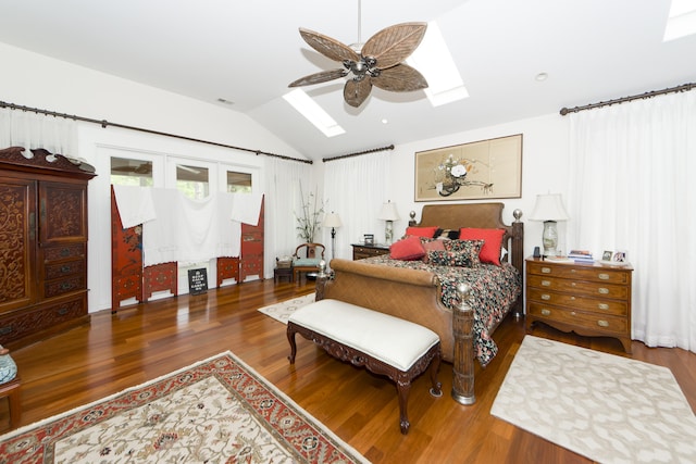 bedroom featuring ceiling fan, vaulted ceiling with skylight, and hardwood / wood-style flooring