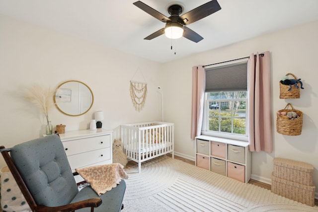 bedroom with ceiling fan and a crib