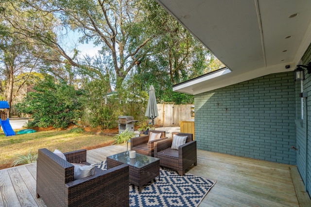 wooden terrace featuring a grill and an outdoor living space