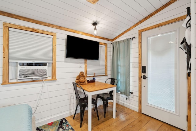 interior space with lofted ceiling, wooden walls, and light wood-type flooring