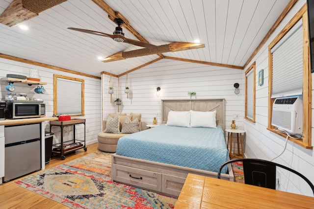 bedroom with wooden walls, lofted ceiling with beams, ceiling fan, and light wood-type flooring