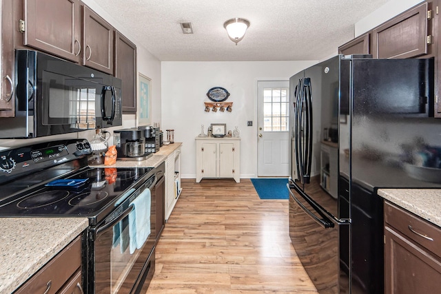 kitchen featuring black appliances, dark brown cabinetry, and a textured ceiling