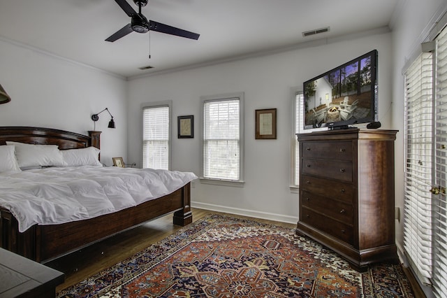 bedroom featuring dark wood-type flooring, ceiling fan, and ornamental molding