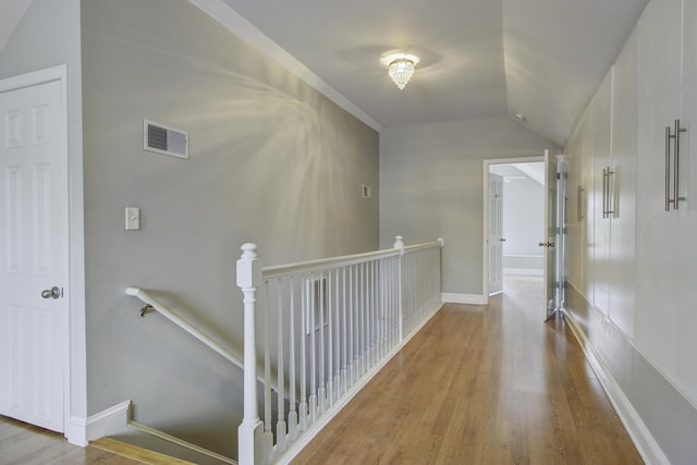 hallway with vaulted ceiling and light hardwood / wood-style floors