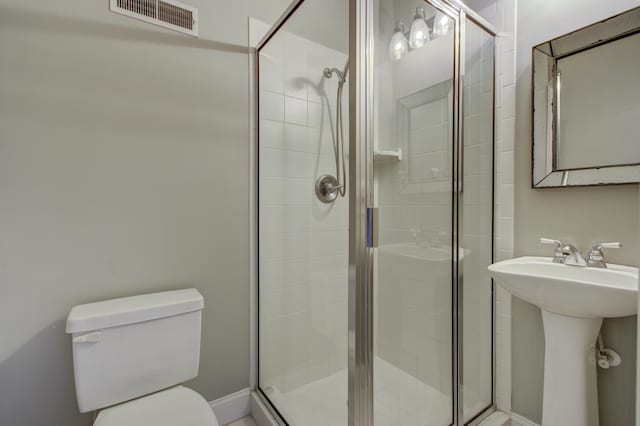 bathroom featuring toilet, sink, and a shower with shower door