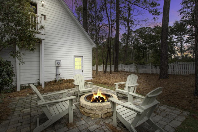 patio terrace at dusk featuring an outdoor fire pit