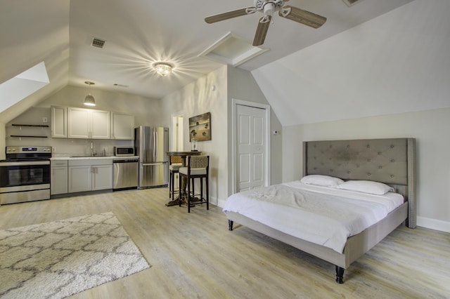 bedroom with lofted ceiling, stainless steel fridge, sink, and light wood-type flooring