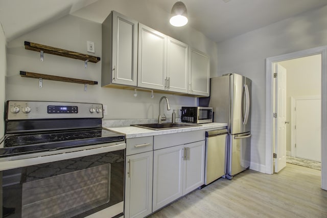 kitchen featuring gray cabinetry, stainless steel appliances, sink, and light wood-type flooring