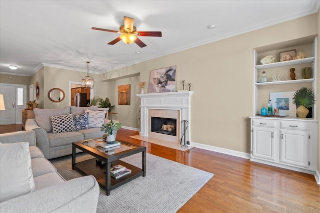 living room with crown molding, ceiling fan, and light wood-type flooring