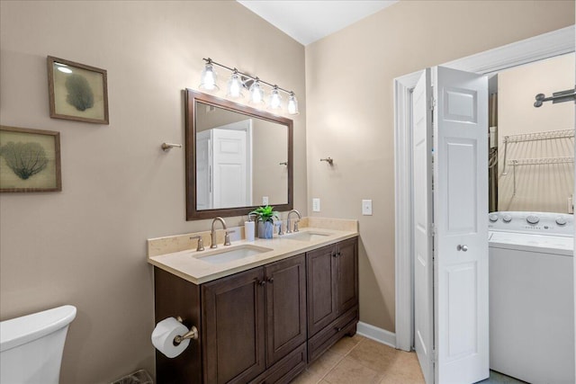 bathroom featuring tile patterned floors, toilet, washer / dryer, and vanity