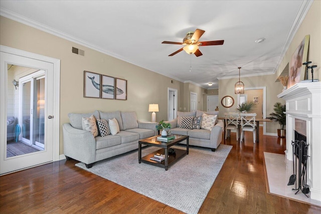 living room with dark hardwood / wood-style floors, ceiling fan, and ornamental molding