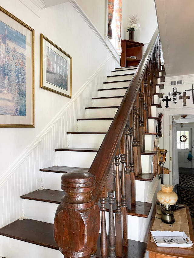 stairs featuring visible vents and a wainscoted wall