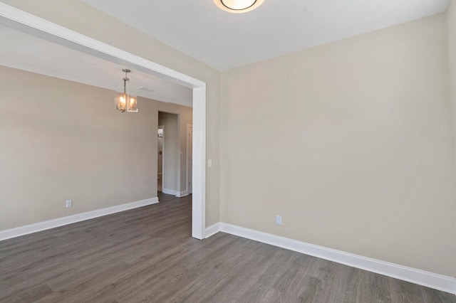 unfurnished room featuring dark wood-type flooring and a chandelier