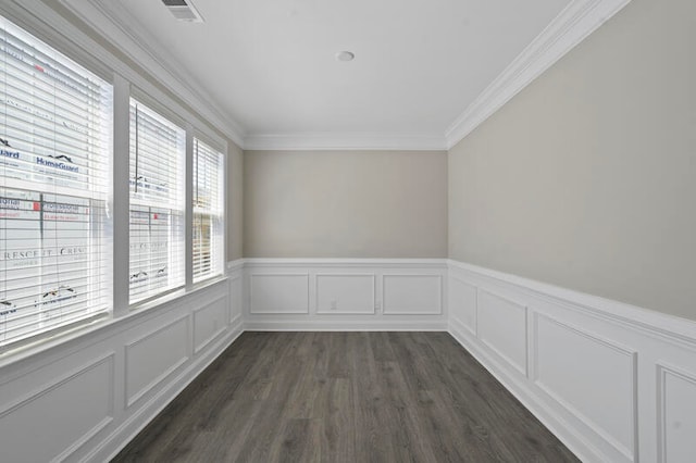 spare room with dark wood-style floors, visible vents, ornamental molding, and a decorative wall