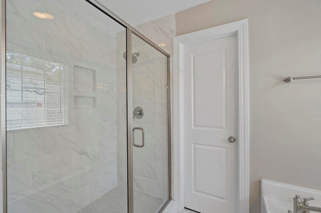 bathroom with a marble finish shower and a washtub