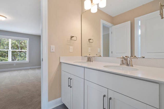 full bath featuring a sink, baseboards, and double vanity