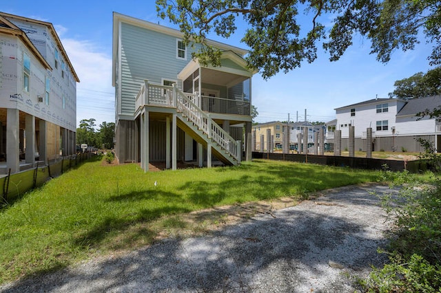 rear view of house with stairway and a lawn