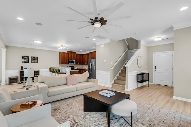 living area featuring crown molding, stairs, ceiling fan, recessed lighting, and light wood finished floors
