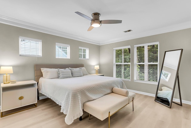 bedroom featuring visible vents, ornamental molding, light wood-style floors, and multiple windows