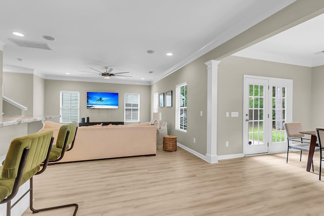 living room featuring a ceiling fan, visible vents, ornamental molding, and light wood finished floors