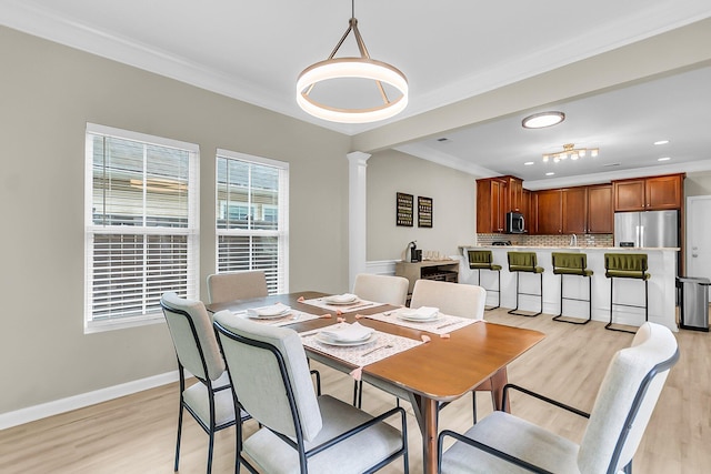 dining room featuring light wood-style flooring, recessed lighting, baseboards, decorative columns, and ornamental molding