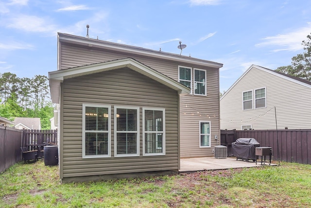 rear view of house with a fenced backyard, a patio, and central air condition unit