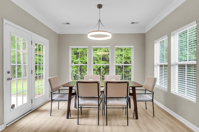 dining space featuring baseboards, visible vents, ornamental molding, and light wood finished floors