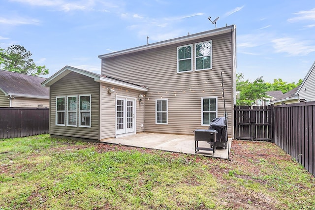 rear view of house with a lawn, a fenced backyard, and a patio area