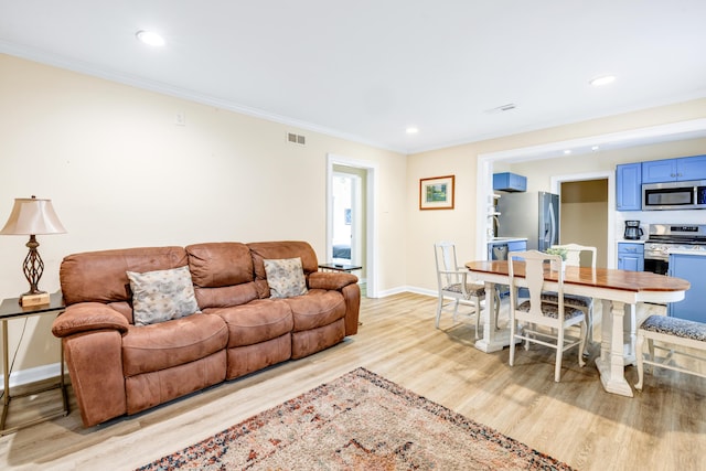 living room featuring crown molding and light wood-type flooring