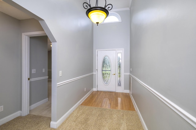 carpeted foyer featuring baseboards