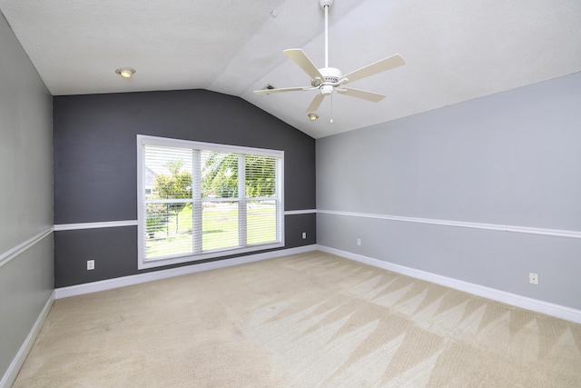 carpeted spare room featuring lofted ceiling, baseboards, a textured ceiling, and ceiling fan