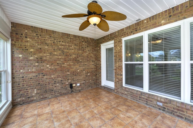 unfurnished sunroom with ceiling fan