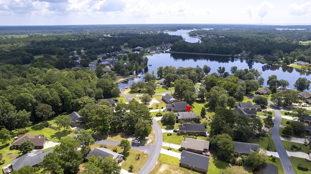 drone / aerial view featuring a water view, a forest view, and a residential view