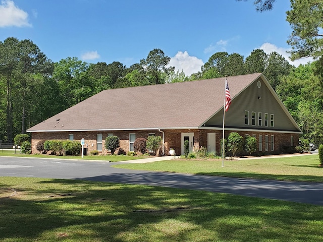 view of front facade featuring brick siding and a front lawn