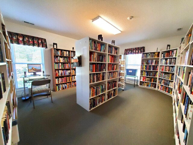sitting room featuring bookshelves and carpet floors