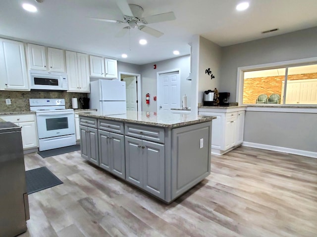 kitchen with white appliances, tasteful backsplash, white cabinetry, gray cabinets, and a center island