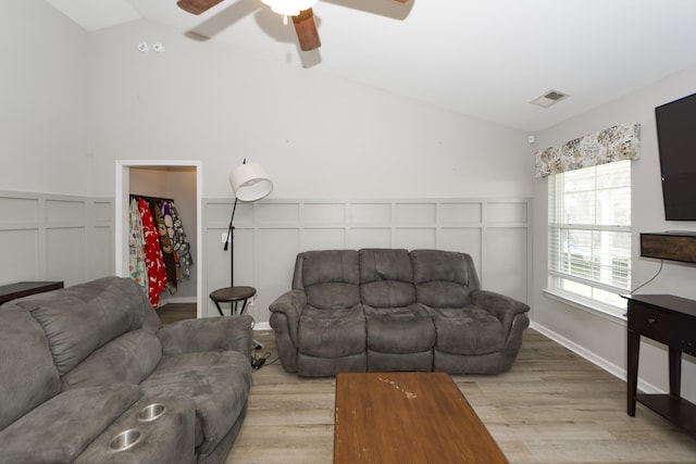 living room featuring light hardwood / wood-style floors, ceiling fan, and vaulted ceiling