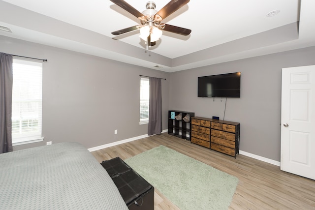 bedroom featuring light hardwood / wood-style flooring, multiple windows, and ceiling fan