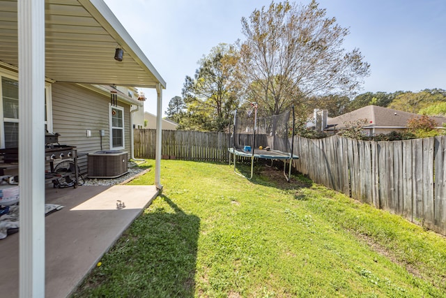 view of yard with a patio, a trampoline, and central air condition unit