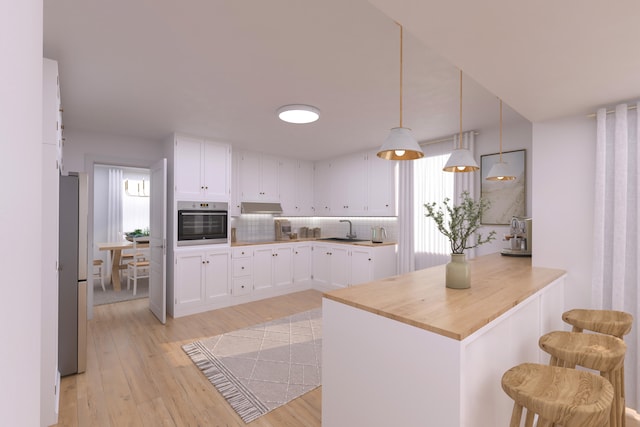 kitchen with kitchen peninsula, white cabinets, decorative light fixtures, and appliances with stainless steel finishes