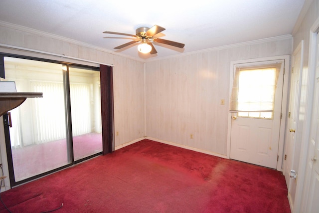 carpeted spare room with ceiling fan and crown molding